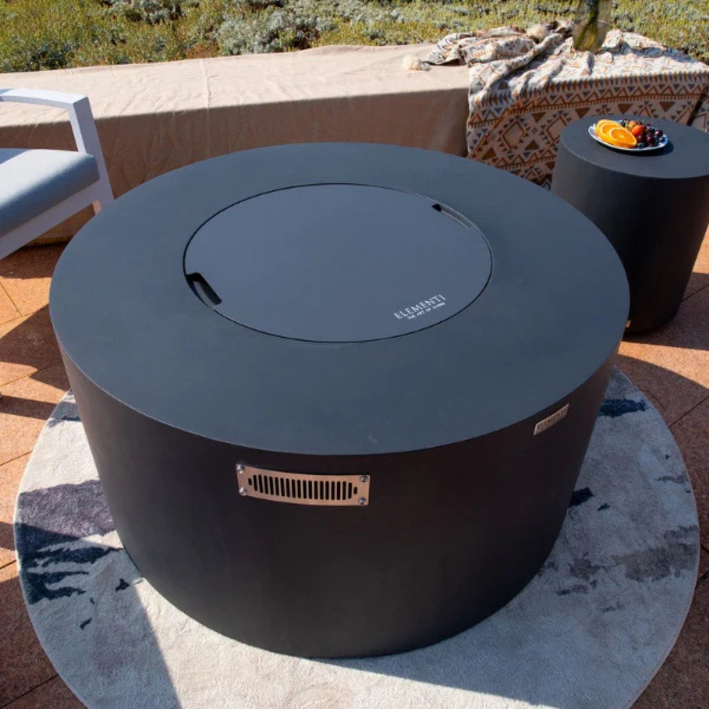 Round outdoor fire pit with lid on a patio