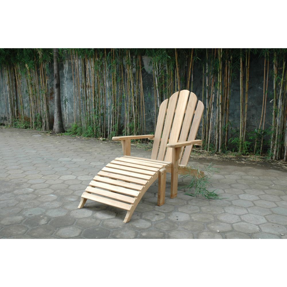 A light natural wood Adirondack-style lounge chair with a matching slatted footrest, placed on a paved patio in front of a bamboo fence.