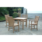 A 5-piece outdoor dining set consisting of a rectangular slat-top table and four matching armchairs, shown on a stone patio with garden plants and a white fence in the background.