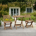 Wooden outdoor table and chairs set on a patio with a garden background