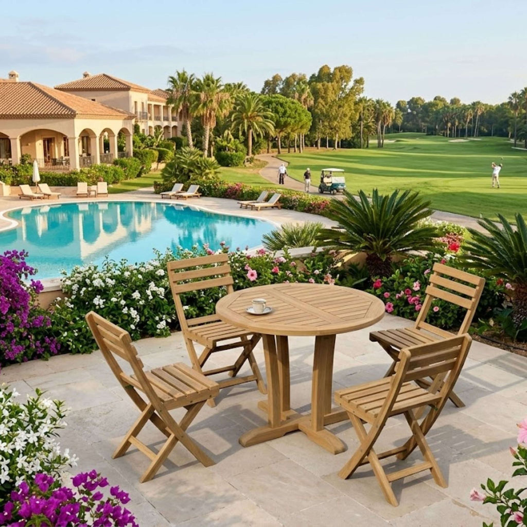 A wooden outdoor patio dining set with a round slatted table and four folding chairs, placed on a stone patio beside a swimming pool and landscaped garden with palm trees and a golf course in the background.