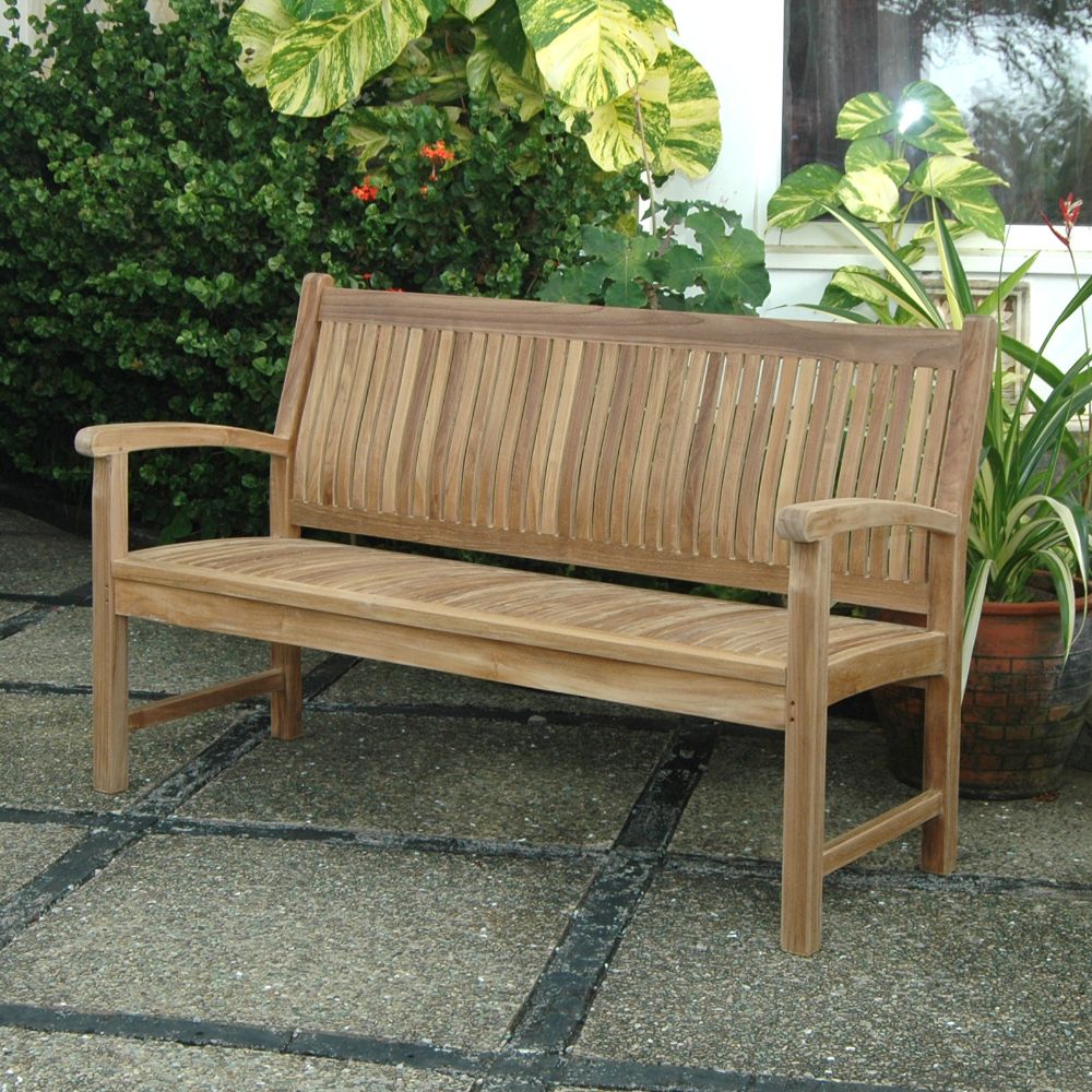 Wooden bench on a patio with plants in the background
