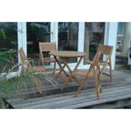 Wooden outdoor table and chairs on a wooden deck with a glass door in the background.