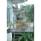 Outdoor patio with wooden furniture and plants on a wooden deck.