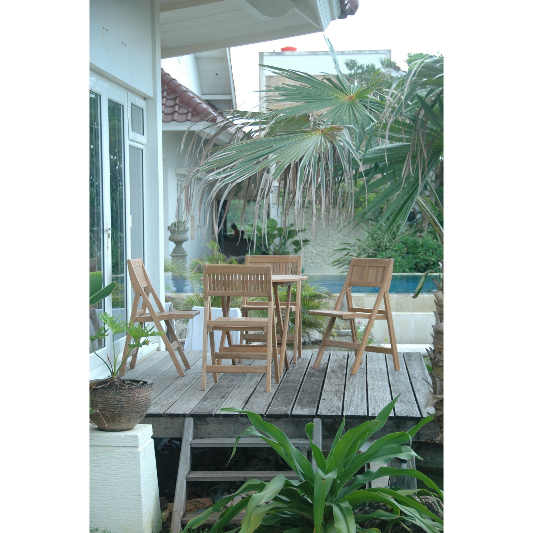 Outdoor patio with wooden furniture and plants on a wooden deck.