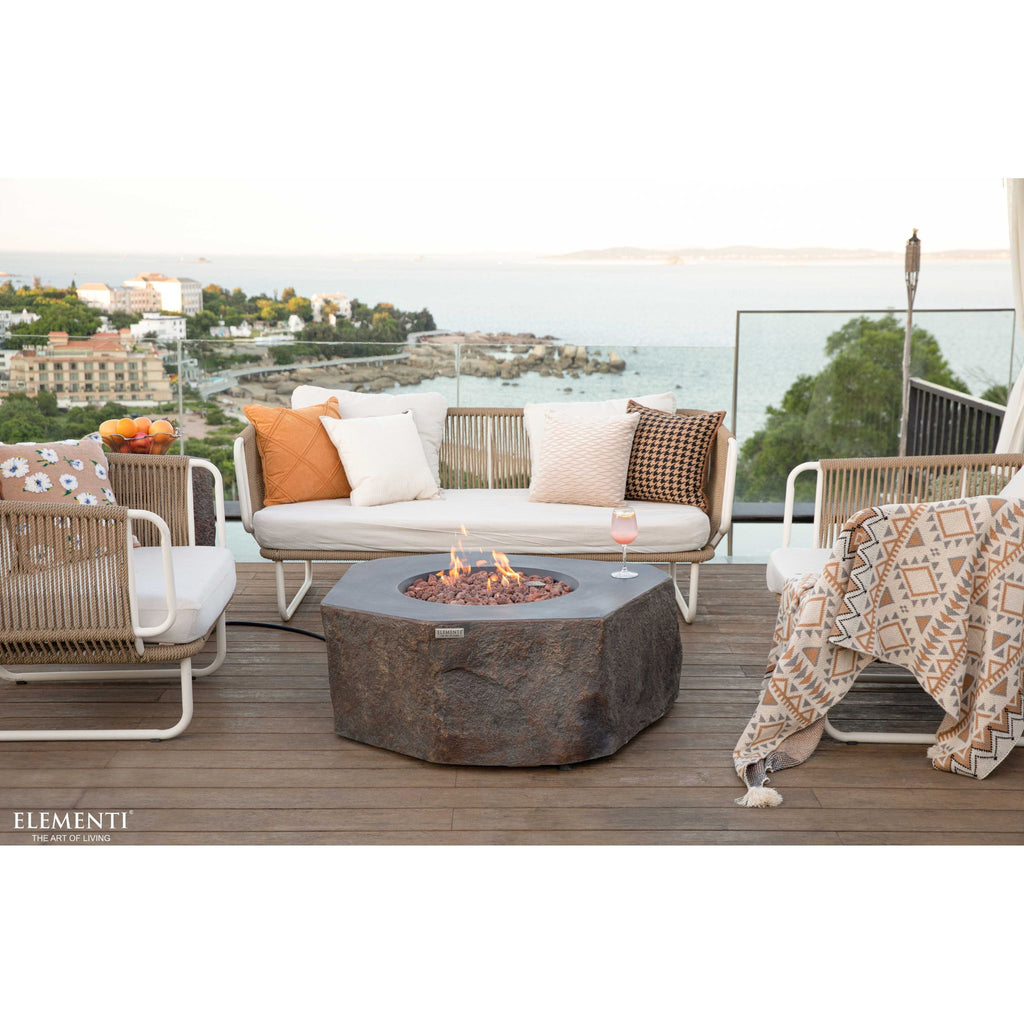 Outdoor patio setting with a fire pit, chairs, and a scenic view.