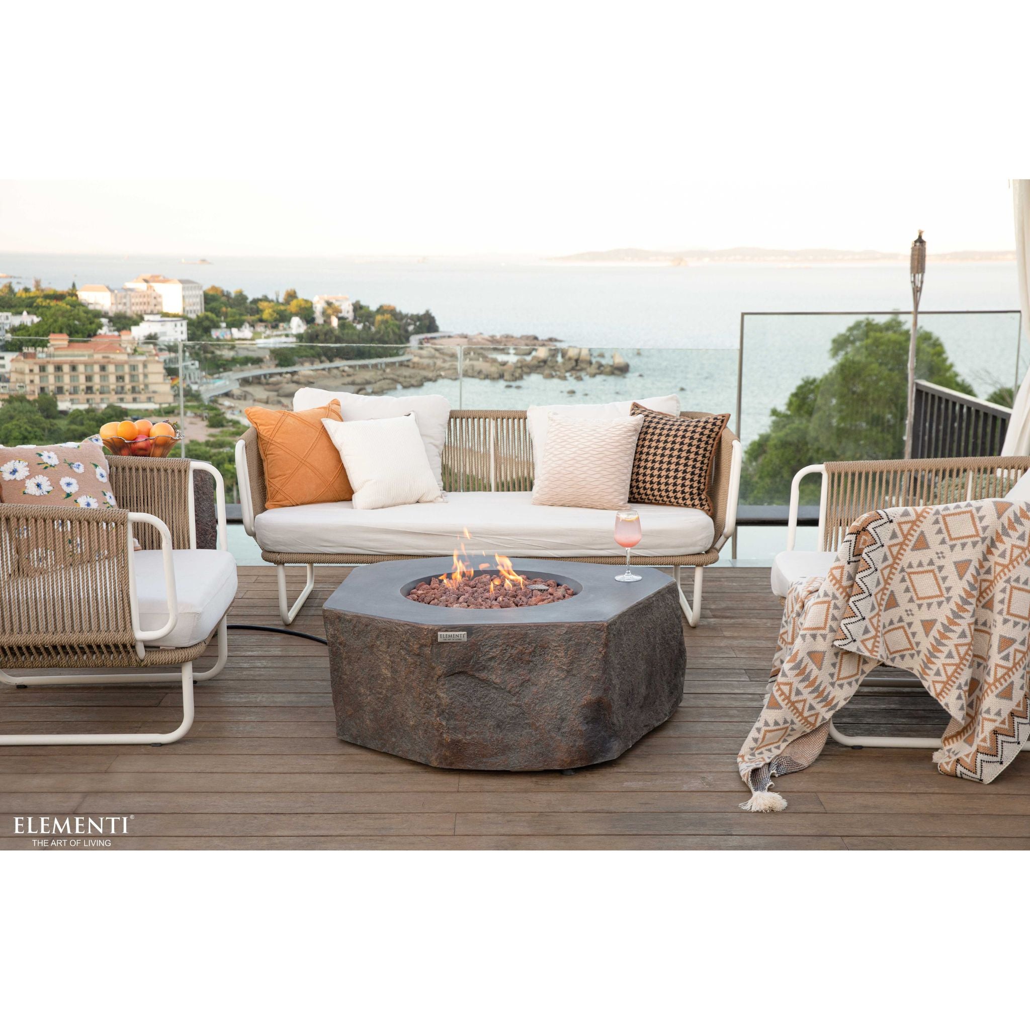 Outdoor patio setting with a fire pit, chairs, and a scenic view.