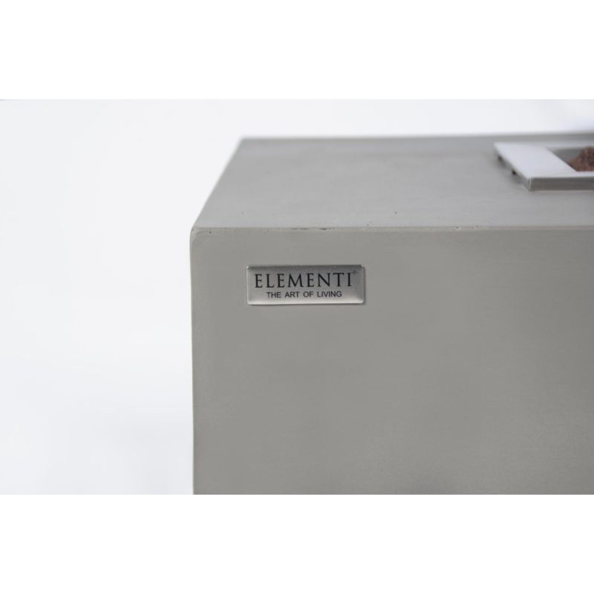Close-up of a light gray rectangular product with a small silver plaque reading 'ELEMENTI THE ART OF LIVING' on a white background.