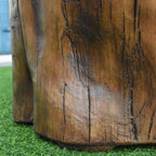 Close-up of a rustic brown faux wood furniture piece, showing detailed wood grain texture and dark weathered cracks, standing on green artificial grass.