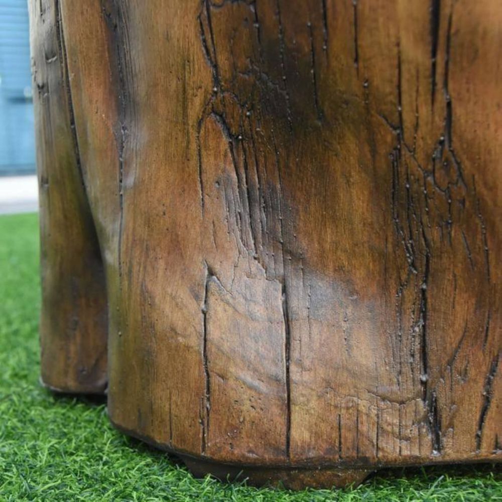 Close-up of a rustic brown faux wood furniture piece, showing detailed wood grain texture and dark weathered cracks, standing on green artificial grass.