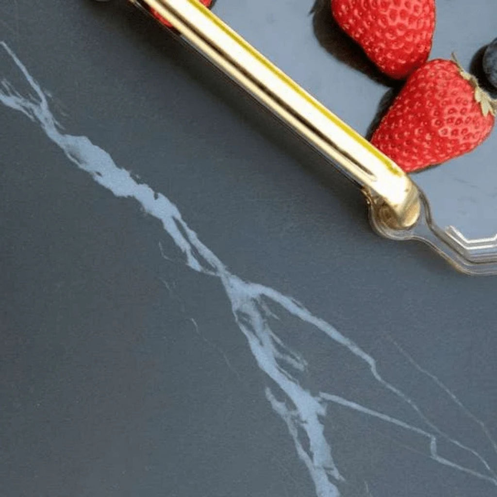 Gold handle on a dark marble surface with strawberries