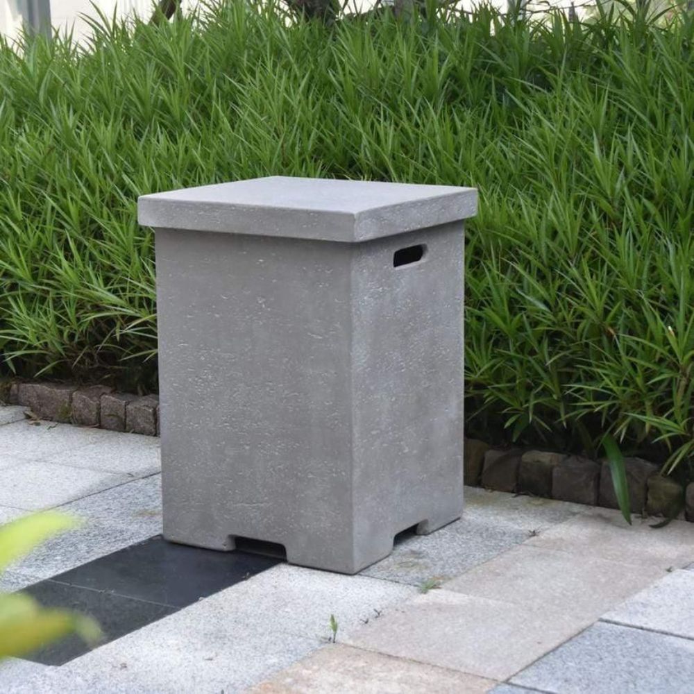 Gray stone bin on a paved area with green grass in the background