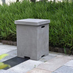 Gray stone bin on a paved area with green grass in the background