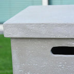 Close-up of a textured gray concrete bench with a blurred green background