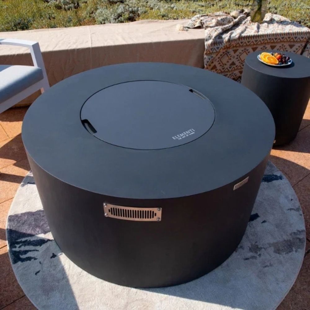 Round outdoor fire pit with lid on a patio