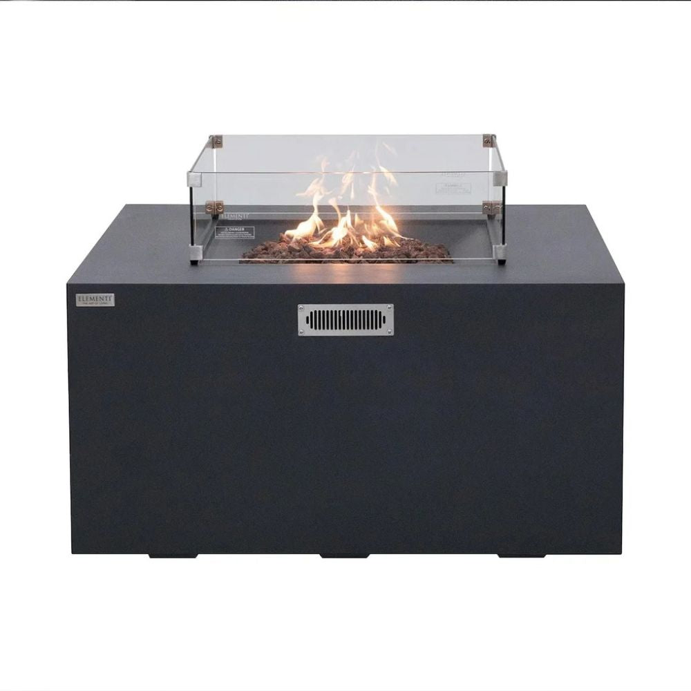 A black outdoor fire pit table with a clear glass wind guard and active flames, shown against a plain white background.