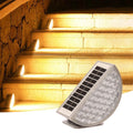 Solar-powered outdoor light fixture illuminating stone steps.