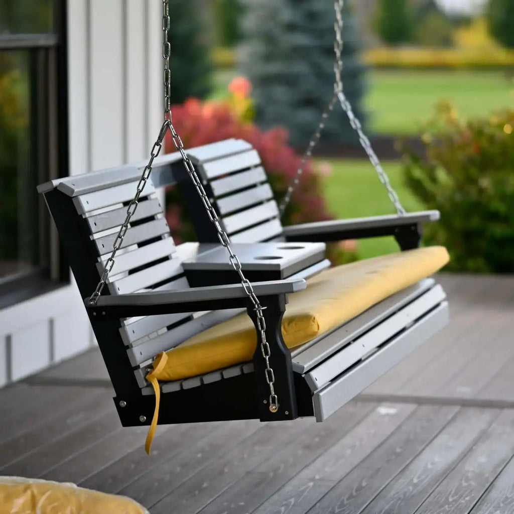 Wooden swing with yellow cushions on a wooden deck