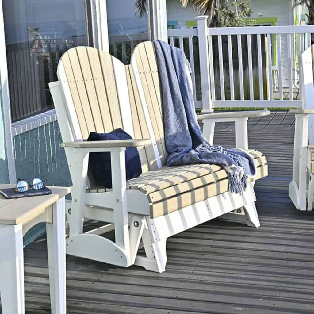 Two Adirondack chairs on a wooden deck with a blue blanket draped over them.