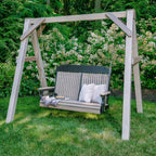 Wooden swing with white cushions in a garden setting