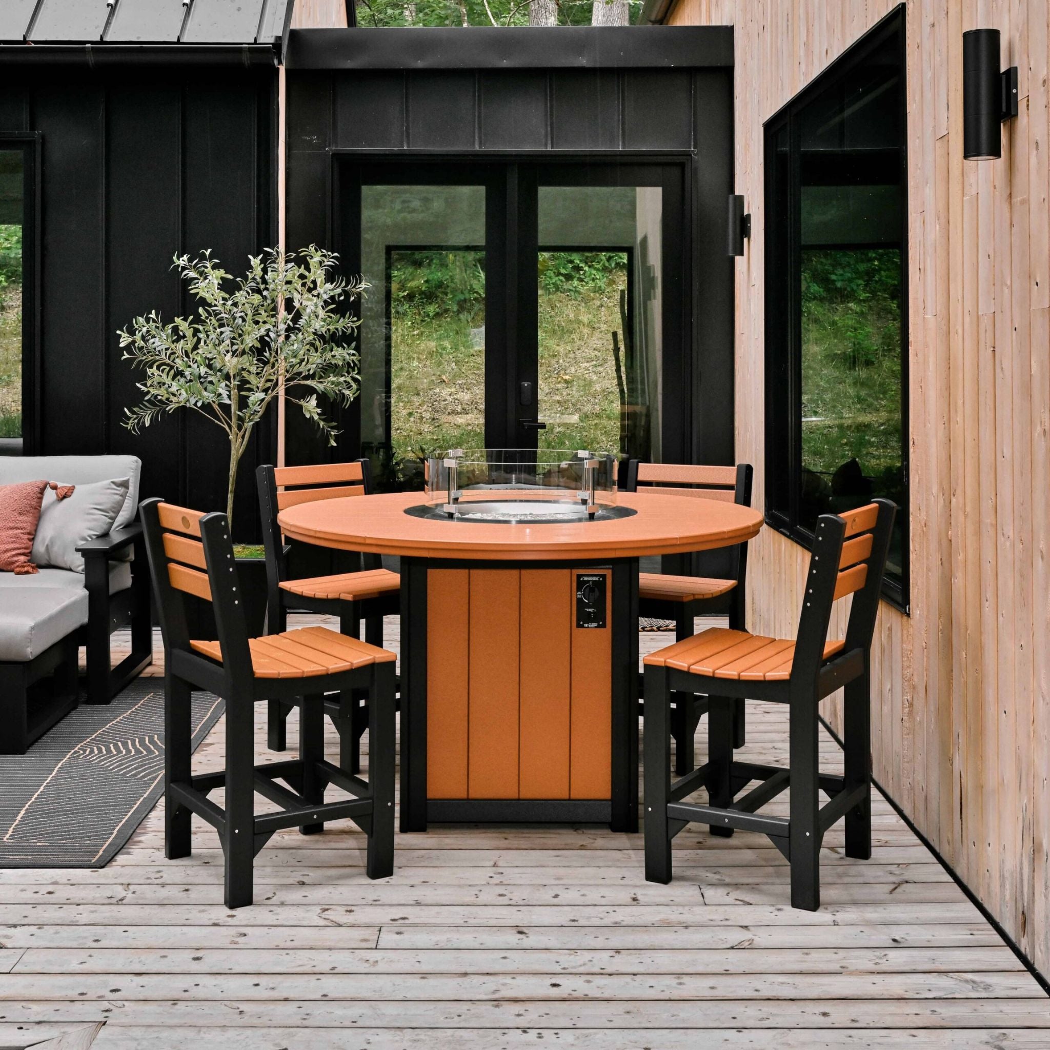 Outdoor patio set with round table and chairs on a wooden deck.