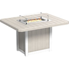 Outdoor fire pit table with a square light beige slatted top, white pedestal base, and a built-in stainless steel firebox with clear glass wind guard and visible flames.