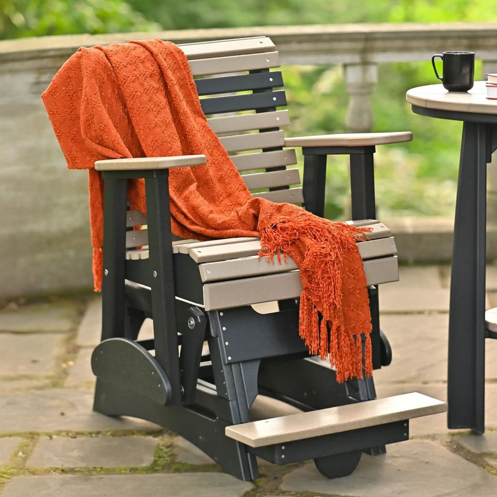 Outdoor swing chair with an orange blanket on a patio