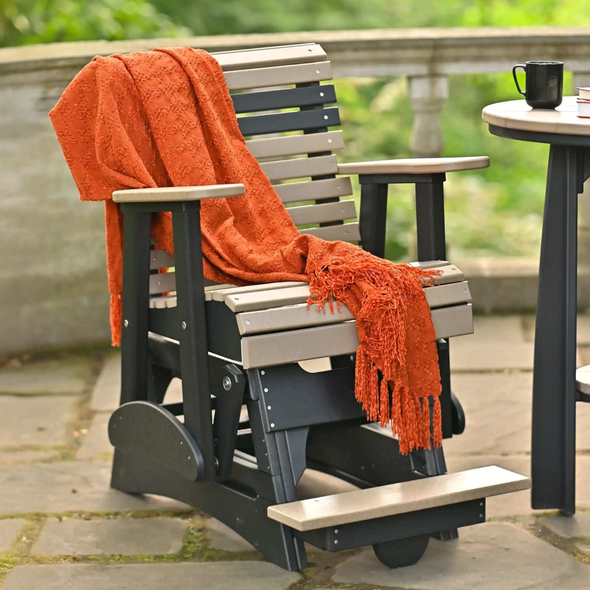 Outdoor swing chair with an orange blanket on a patio