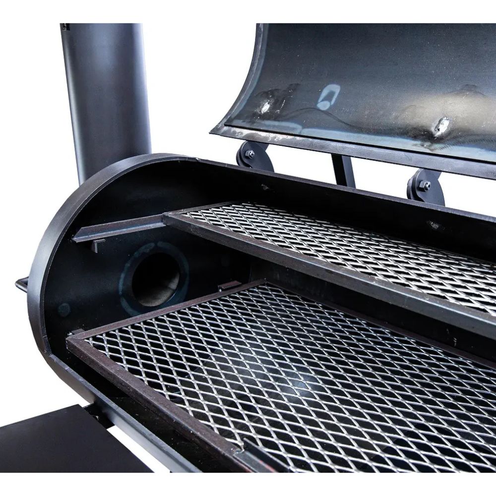 Close-up of a grill with open lid showing grates and smoke.