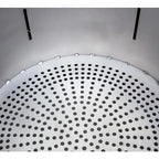 Round metallic object with perforated design on a gray background