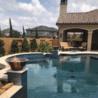 Pool area with patio furniture, fire pit, and house in the background