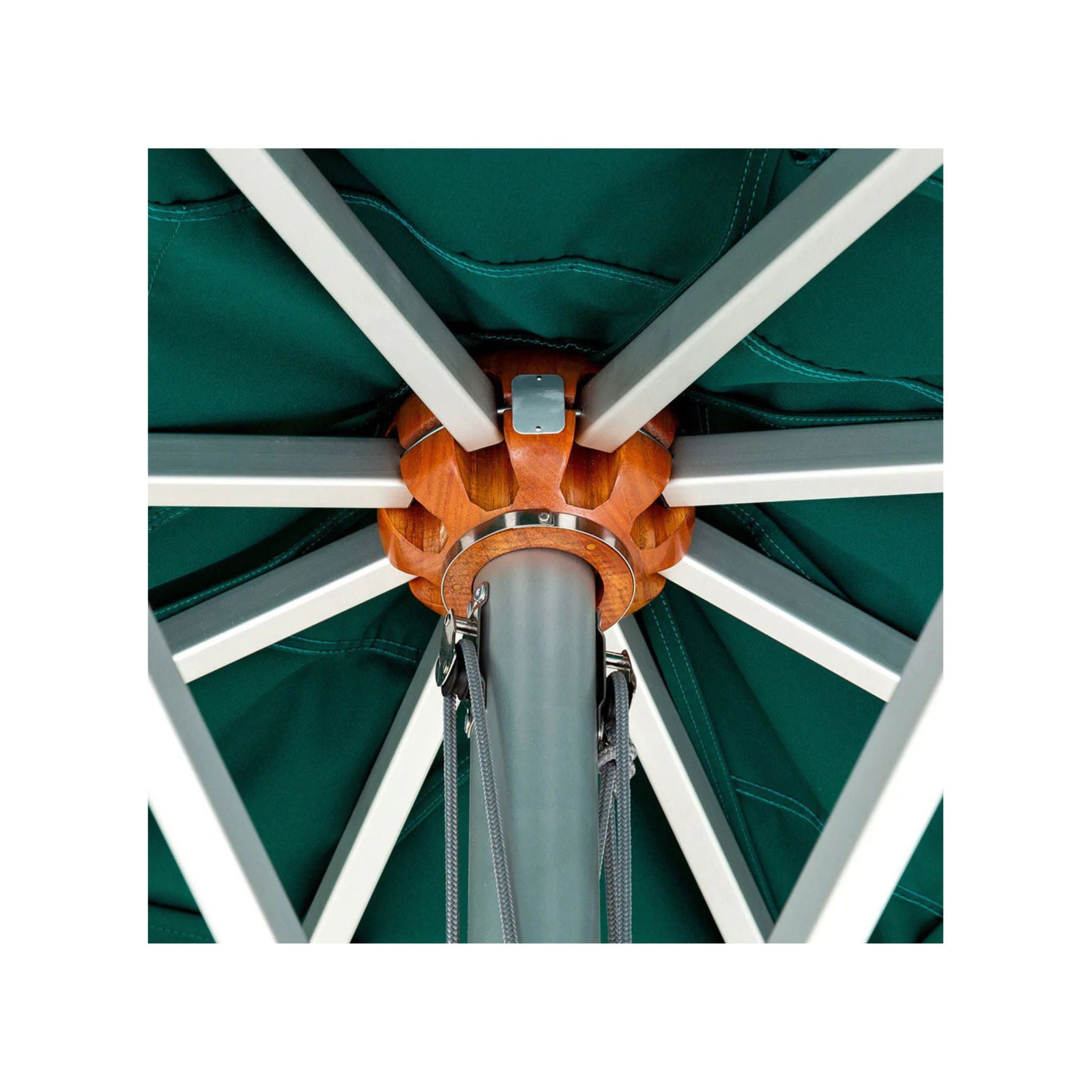 Close-up detail of an outdoor umbrella canopy showing the dark green fabric, white support ribs, and central orange and gray metal hub.