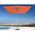 An orange and red striped patio umbrella with a silver metal pole, positioned next to a swimming pool with a beach and ocean view in the background.