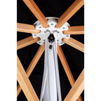 Close-up of a canopy attachment point with light natural wood radial ribs, a white central hub, and white hanging straps against a black canopy background.