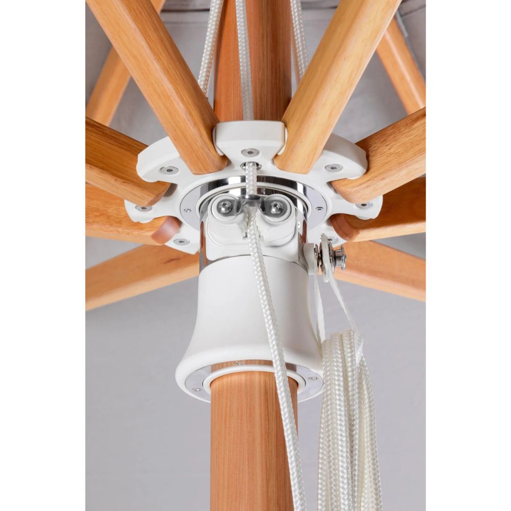 Close-up of the underside of a patio umbrella showing the white canopy attachment, wooden ribs, metal hardware, and white rope pull cords against a light gray background.